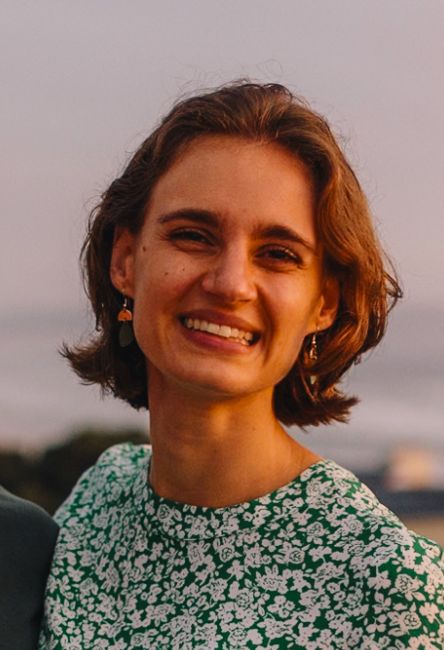Smiling woman with short brown hair in a green floral dress
